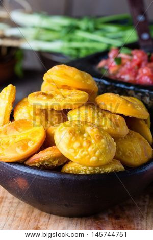 Sopaipilla. Latin American food. Traditional chilenian homemade pumpkin sopaipillas with typical mexican salsa - tomato sauce in stone mortar on rustic cutting board on wooden background