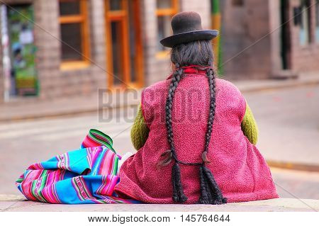 Local woman sitting at Plaza de Armas in Cusco Peru. In 1983 Cusco was declared a World Heritage Site by UNESCO