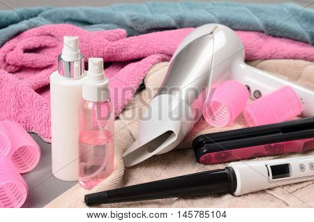 Hair Styling Tools (white Hairdryer, Hairspray, Curler, Spray, Cone Curling Wand) On Beige Towel
