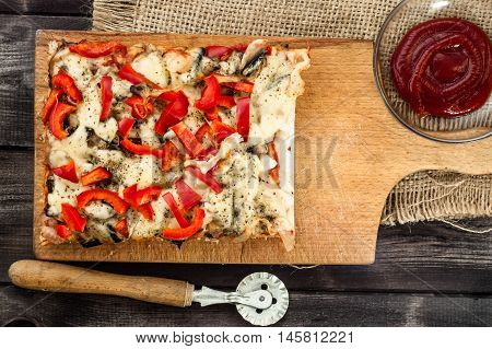 Portion of pizza on wooden background. Homemade cooking concept.
