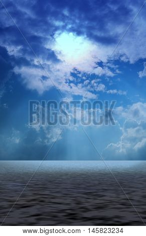 Clouds with sun beams signing through onto serene soft wavy sea