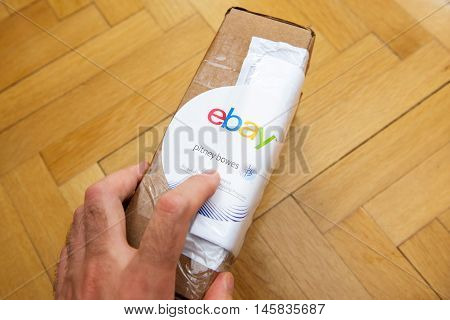 PARIS FRANCE - JUN 8 2016: Man hoding Ebay and Pitney Bowens box logotype printed on cardboard box security scotch tape of International Shipping Program.