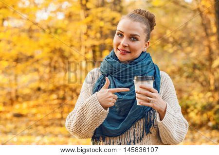 Smiling Young Female Pointing At Coffee