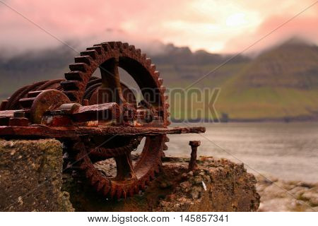 Rusted iron wheal at the coastline in the Faroe Islands