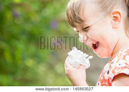 Young Girl With Hayfever Sneezing In Garden