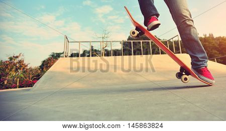 closeup of skateboarder legs skateboarding at skatepark