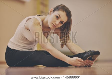 fit young women doing stretching exercises in fitness studio