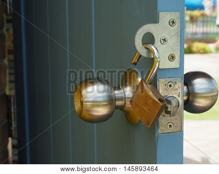 Padlock hangs on the opened wooden door