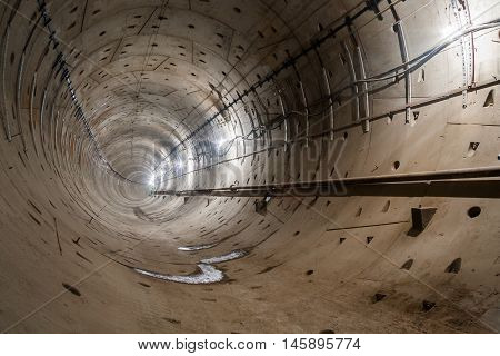 direct subway tunnel with a circular section and rails goes straight into the distance.