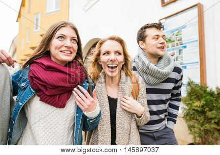 Group of young people talking, having fun outside in town