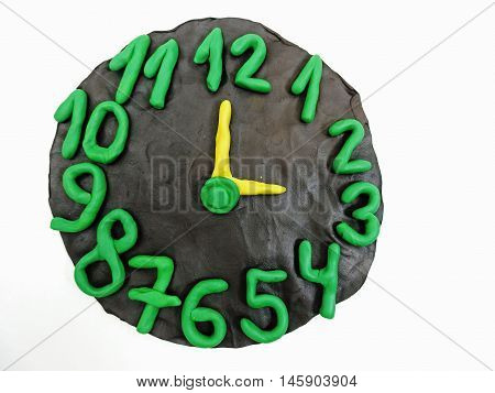 Round clock from plasticine on white background
