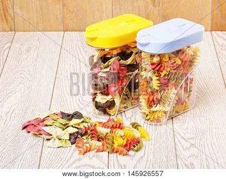 raw fancy pasta of different color in plastic containers