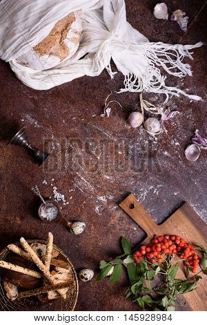 Bread loaf with various ingredients on rustic kitchen top. Autumn theme. Copy space, top view.