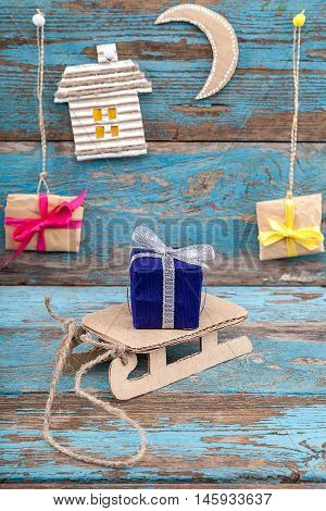 Christmas decorations with sleigh and gifts on wooden boards painted in blue.