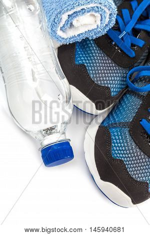 Sport shoes towels and water bottle isolated on a white background.