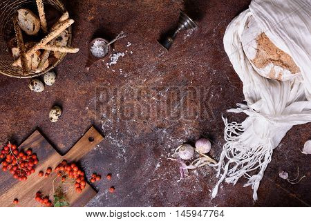 Bread, bread sticks and buns with ingredients over rustic background. Food frame, view from above, copy space.