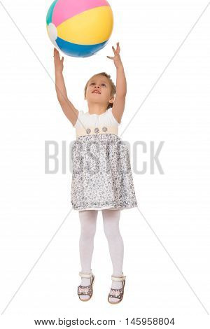 Cheerful Caucasian little girl in grey short dress jumping . The girl photographed at the time of the jump. Girl catches the ball in flight - Isolated on white background