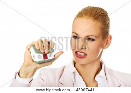 Aggresive business woman crushing small house