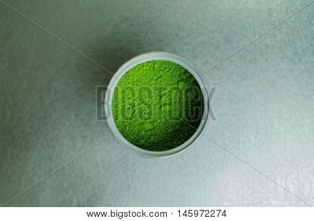 Matcha - Japanese green tea powder in a can on silver background