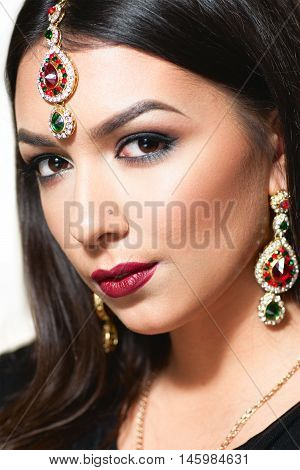 Beautiful Indian woman portrait with golden jewelry. Gorgeous arabic girl eyes. Beautiful Hindustani princess