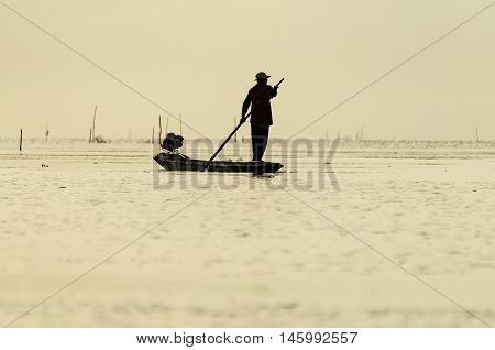 Silhouettes of the traditional stilt fishermen at sunset