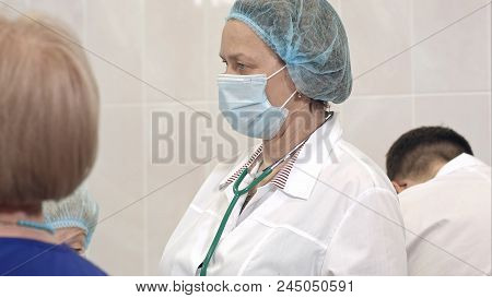 Serious Female Doctor In Mask Standing In A Surgical Room