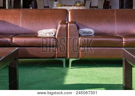 Close Up Modern Elegant Brown Leather Lounge Sofa With Woolen Throw Rug Blanket On The Arm. Interior
