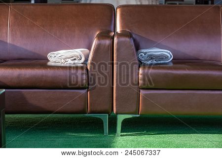 Close Up Modern Elegant Brown Leather Lounge Sofa With Woolen Throw Rug Blanket On The Arm. Interior