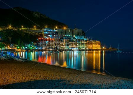 Montenegro, Rafailovici - June 05/2017: Tourists Walk Along The Picturesque Night Embankment On The