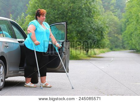 Disabled woman upgoing from a car. Transportation and travel for handicapped people.