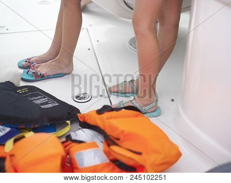 Life Vests On The Marina Floor And Children Standing, Outdoor Cropped Shot