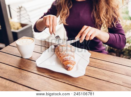 Stylish Woman Eating Croissant With Knife And Fork. Picture Of Tasty Breakfast With Cappuccino In Eu