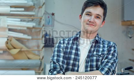 Cheerful Young Workre In A Frame Atelier Workshop Smiling And