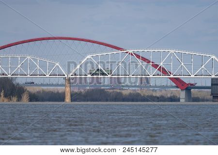 The Train Travels Along The Railway Bridge Across The River