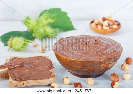 Homemade Hazelnut Spread In Wooden Bowl. Hazelnut Nougat Cream On Slice Of Bread