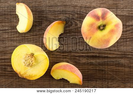 One Yellow Peach, A Section Half And Three Slices, Flatlay, On Brown Wood Background