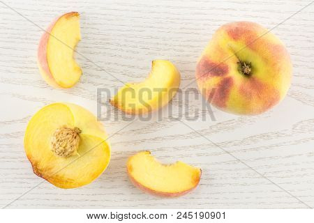 One Yellow Peach, A Section Half And Three Slices, Flatlay, On Grey Wood Background