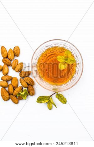 Beneficial And Essential Oil Of Badam Or Almonds With Its Beneficial Tea In A Transparent Cup Isolat
