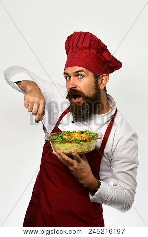 Man With Beard On White Background. Chef Holds Bowl With Potato Casserole And Fork Ready To Eat. Hea