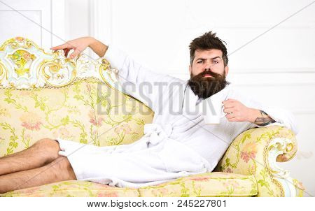 Man On Thoughtful Face In Bathrobe Drink Coffee In Luxury Hotel In Morning, White Background. Luxury
