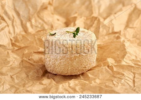Crottin Cheese With Thyme Leaves On Brown Package Paper.