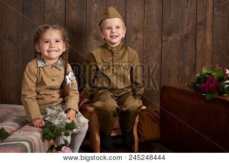 children are dressed in retro military uniforms sending a soldier to the army, dark wood background, retro style