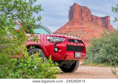 Moab - May 5, 2018: Toyota 4Runner SUV  and a sandstone butte in Utah landscape at Rocky Rapid river access area.