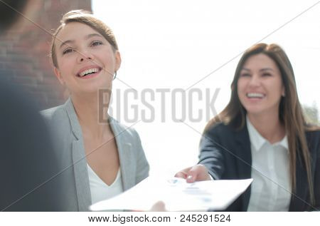 assistant passes business woman working document