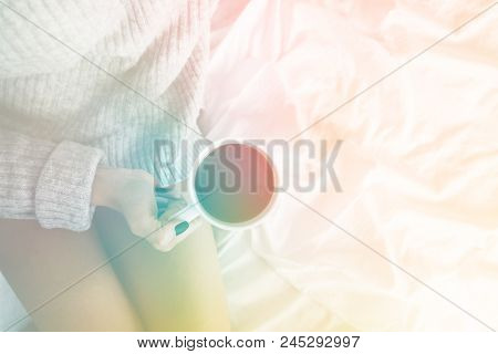 Girl In Bed Wearing Wool Sweater Holding Cup Of Coffee