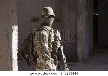 Full Face Mask Soldier Look On Camera With Back Pack And Rifle