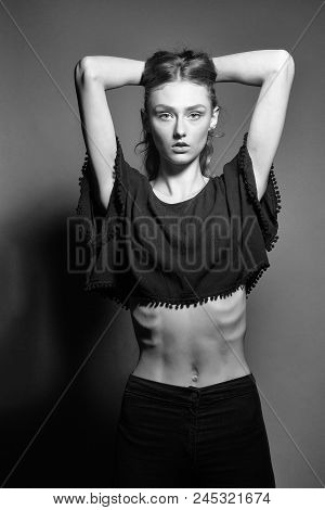 Athletic Body. Young Girl With Pretty Serious Face In Black Short Top With Bare Belly And Slim Rib B