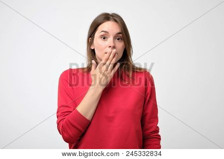 Close Up Portrait Of Attractive, Charming, Woman In Red Pulover Closing Her Mouth With Fingers. She 