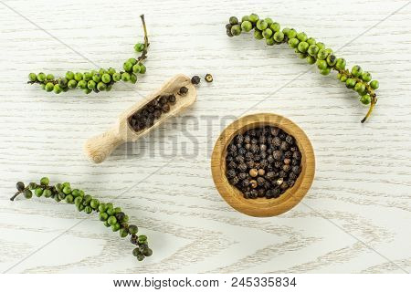 Unripe Drupes Of Fresh Black Pepper Flatlay On Grey Wood Backgound Four Bunches One Wooden Bowl And 