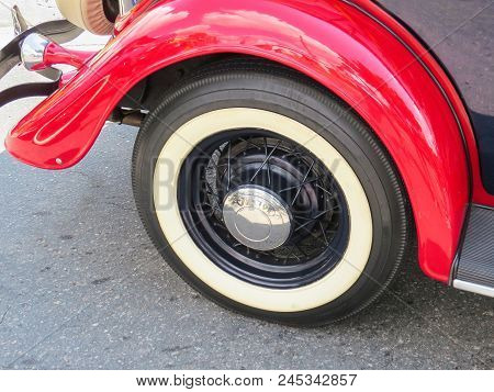Detail Of Classic Old Car, Wheel And Red Fender, With Chrome Shell.